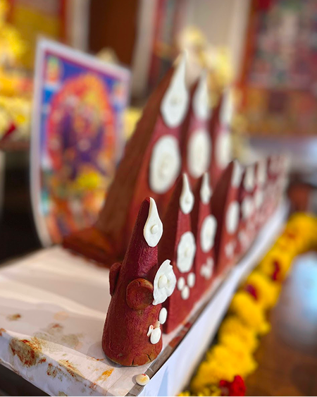 Ornate torma offering sculptures arranged on the shrine